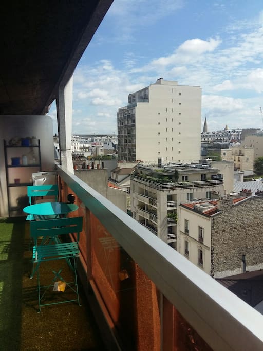 balcon équipé d'une table et deux chaise et d'un transat