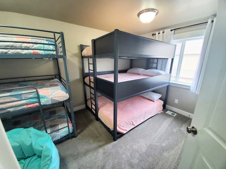 Upstairs bedroom #3 with queen triple bunk, twin triple bunk, and blackout curtains. Also has mounted 50" smart TV with complimentary Netflix, Disney+, and YouTubeTV signed in and ready for you.