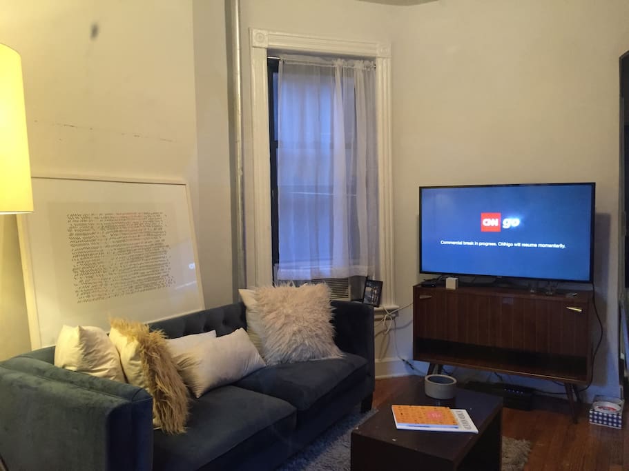 Living room with large couch, access to free wifi and Apple TV