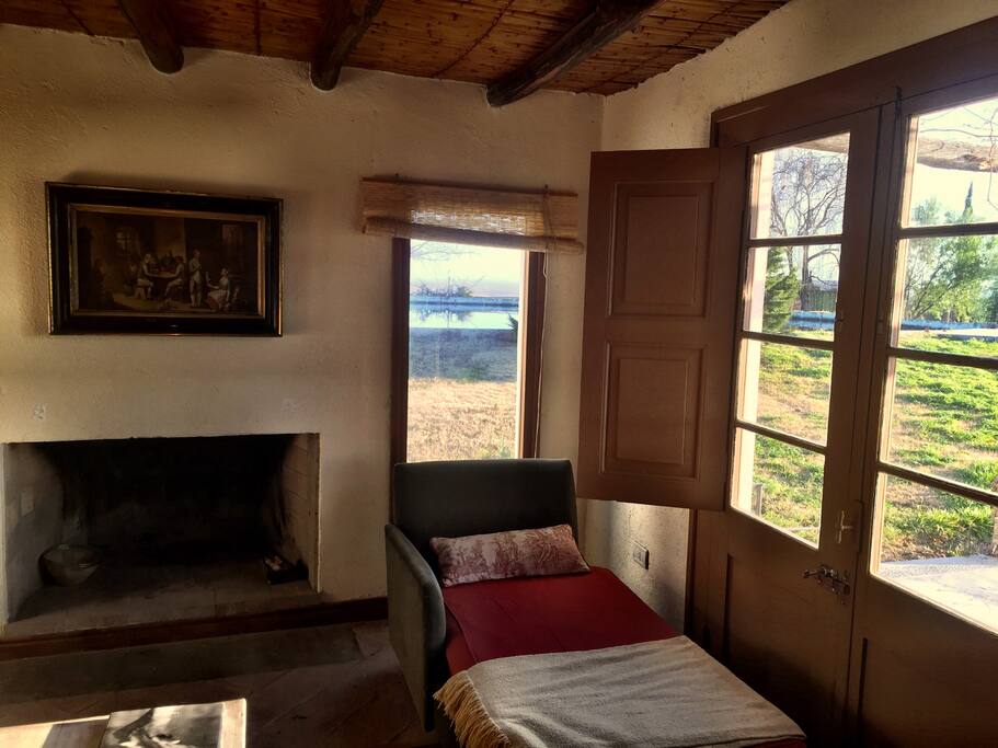 Winter reading by the window and fireplace. In the window you can see the water tank (good for swimming in the summer)