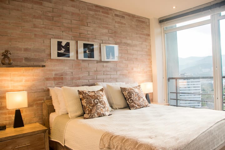 Relax in this serene bedroom featuring soft linens, modern decor, and a tranquil atmosphere for a restful night’s sleep.