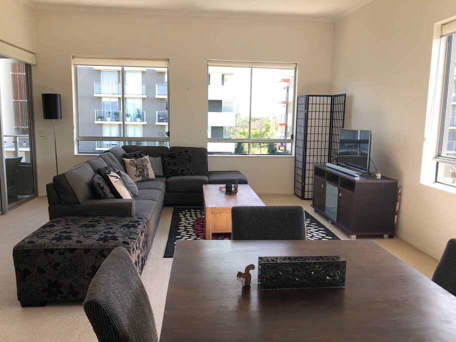 Open space living area with smart tv, large comfortable couch, dining area and balcony just to the left. You are welcome to use the guest profile on my Netflix account.