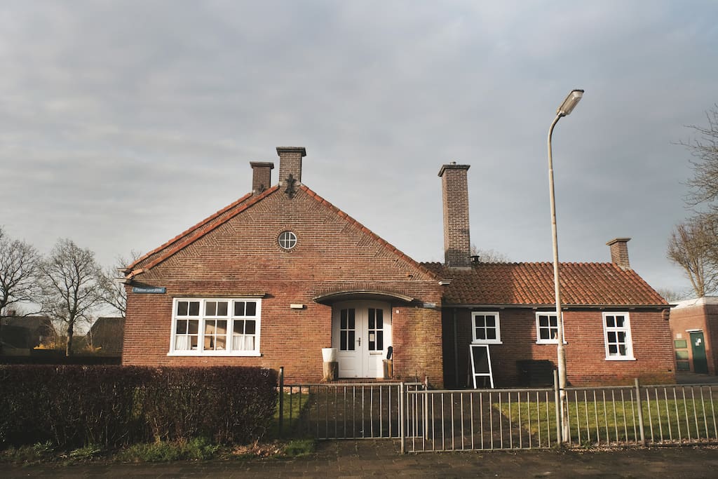 Het Skoallehus, de voormalige basisschool in Wierum. Dit is de voordeur naar het WierWarenHuis en tevens je eigen ingang naar het SlaapLokaal.