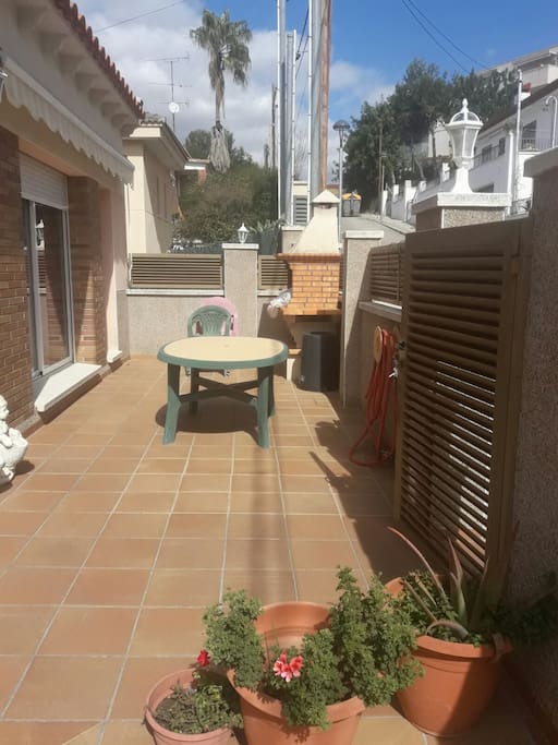 Entrada a casa por una terraza con Barbacoa y abertura a la cocina