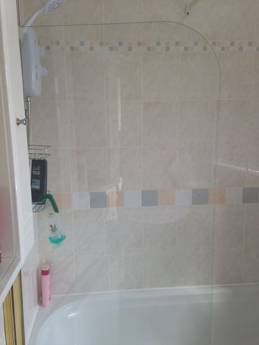 Private downstairs bathroom with shower over bath