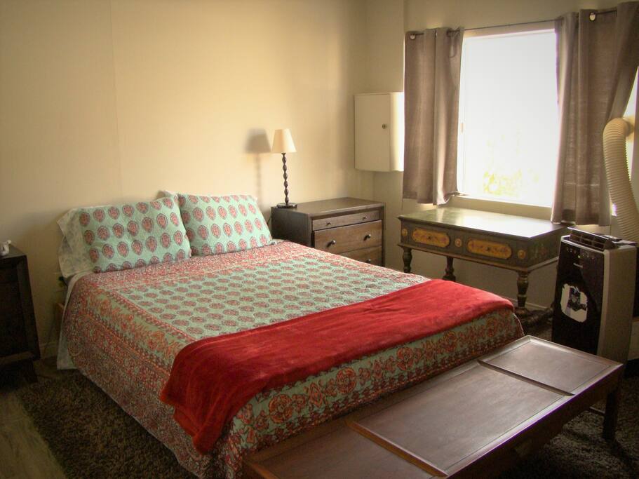 Bedroom with light blocking curtains and air conditioner for hot weather