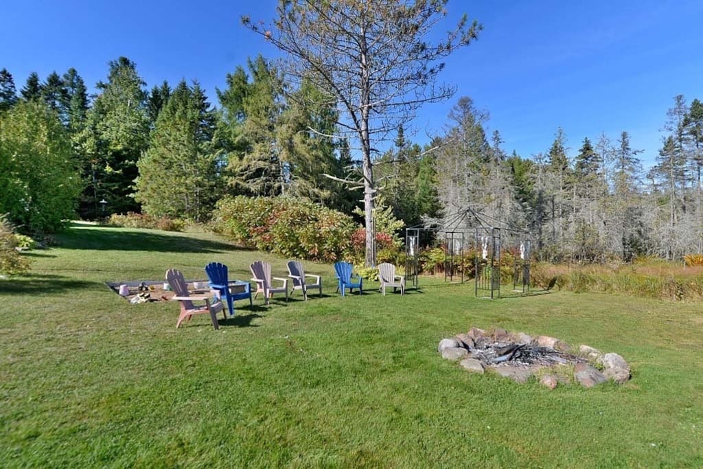 Endroit pour faire un feu avec bois et chaises disponibles.
Fire pit with wood and chairs available.