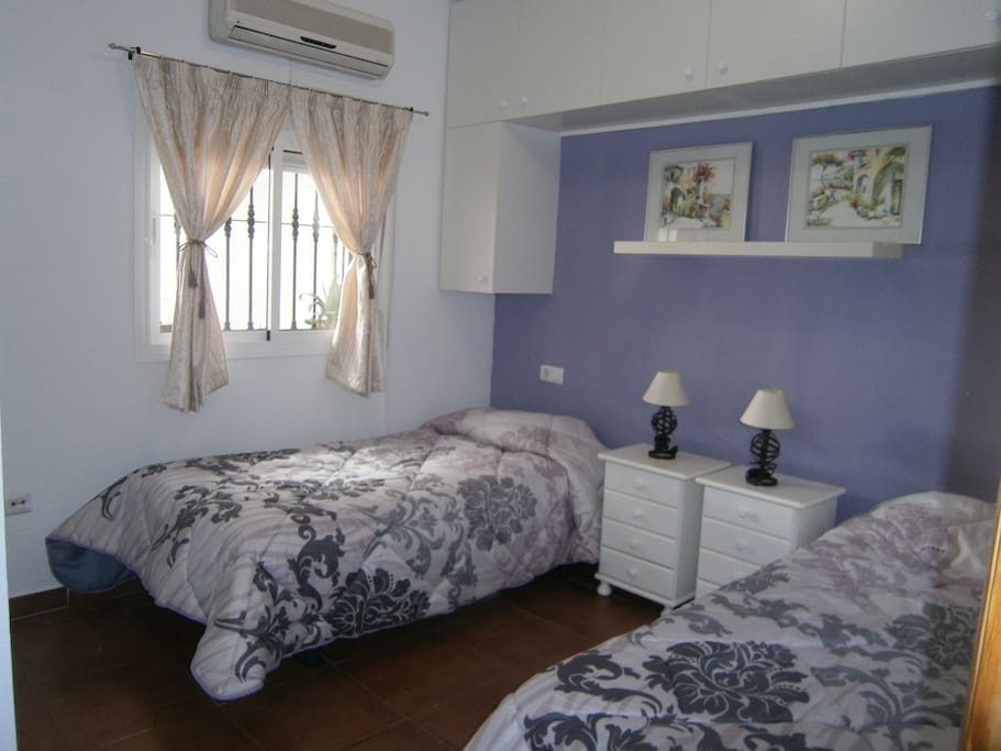 amplia habitación con dos camas y aire acondicionado.