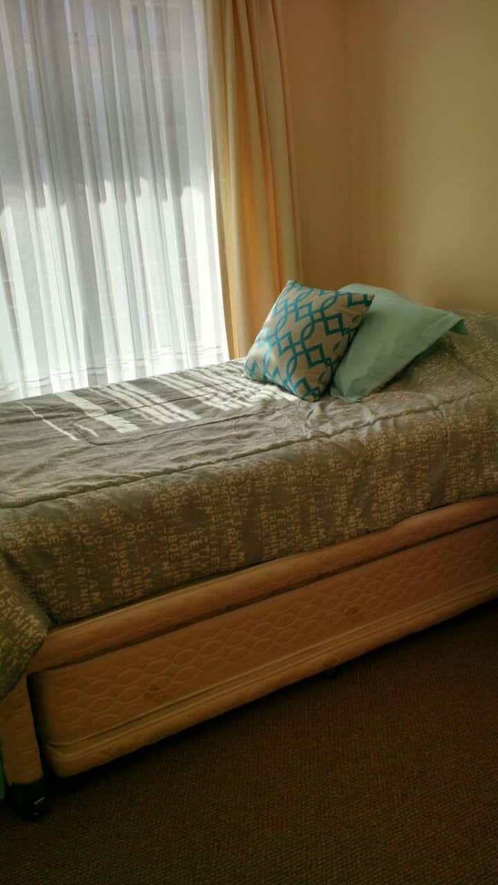 Dormitorio pequeño con clóset y cama nido.