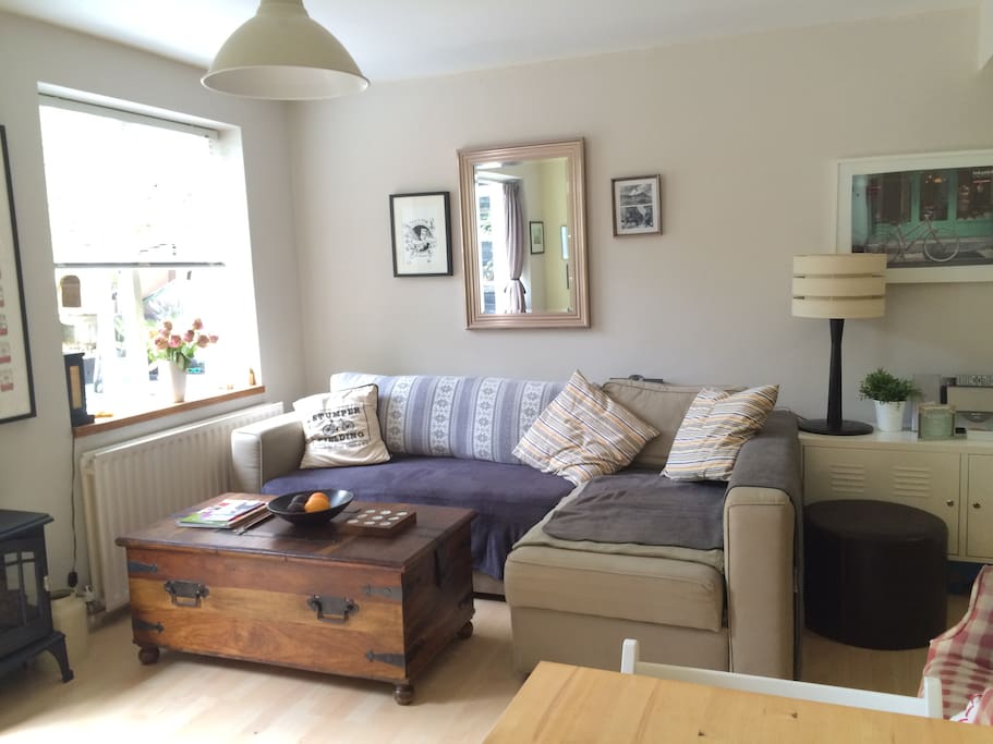 This is another section of the living room, with a large sofa.
The living room is very quiet and overlooks & has direct access to the private garden which is a sun trap in the summer.