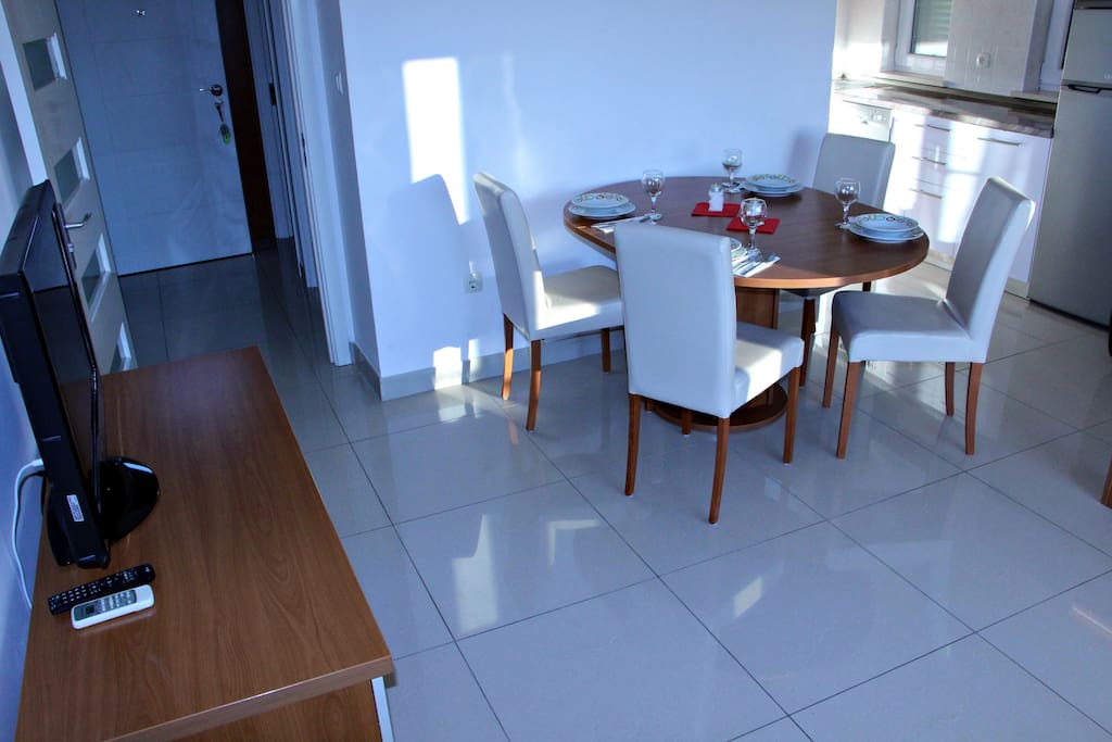 Living room with dining table and TV set.