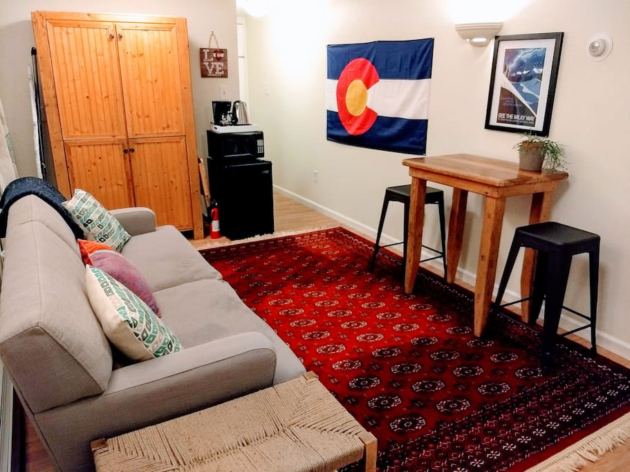 Our bright, cozy living area of our Colorado-themed guest suit features vintage post cards of local attractions and art by local artists.