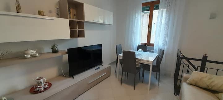 Sebule iliyo na runinga janja na taa ya dari iliyo na feni inayopotea.