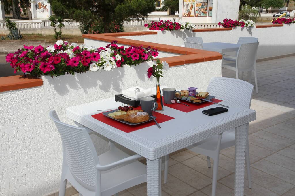 Pui consumare la ricca colazione a buffet su un ampio terrazzo fiorito