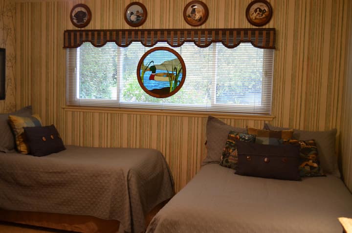 配有双人床和单人床的卧室，下面有带轮活动床