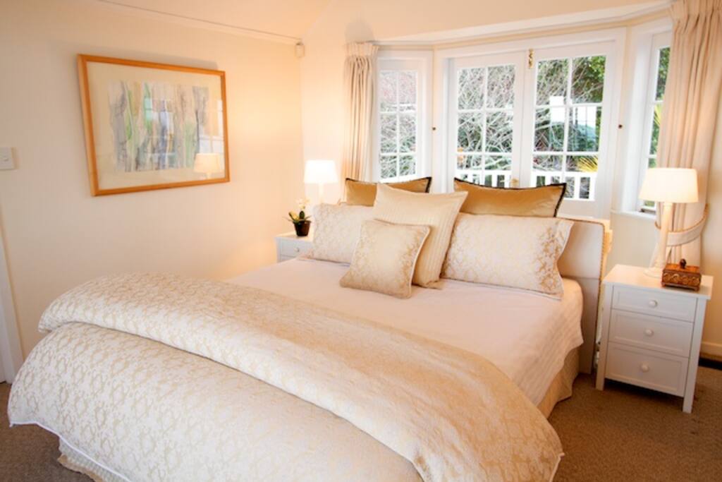 King bed in upstairs master bedroom overlooking Takapuna Beach