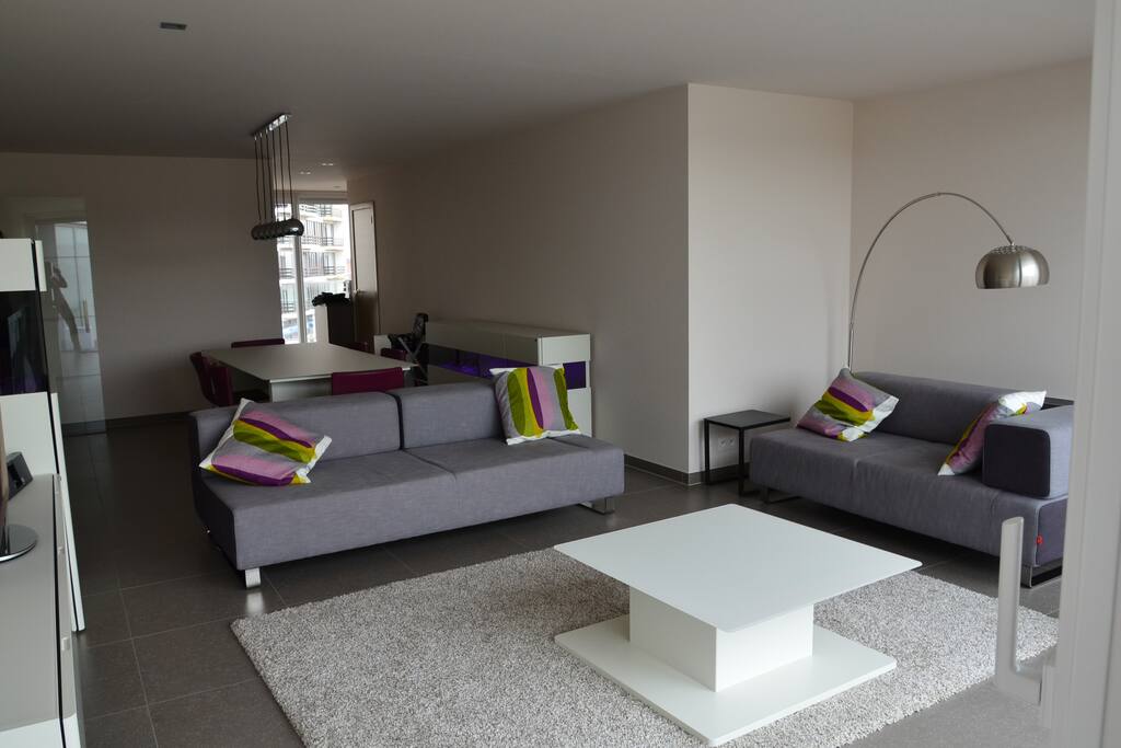 Ruime woonkamer met zithoek, eettafel en open keuken