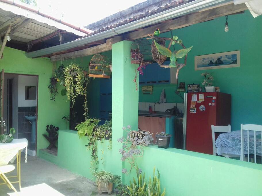 área com cozinha compartilhada, fogão, geladeira, e espaço para mesas e cadeiras