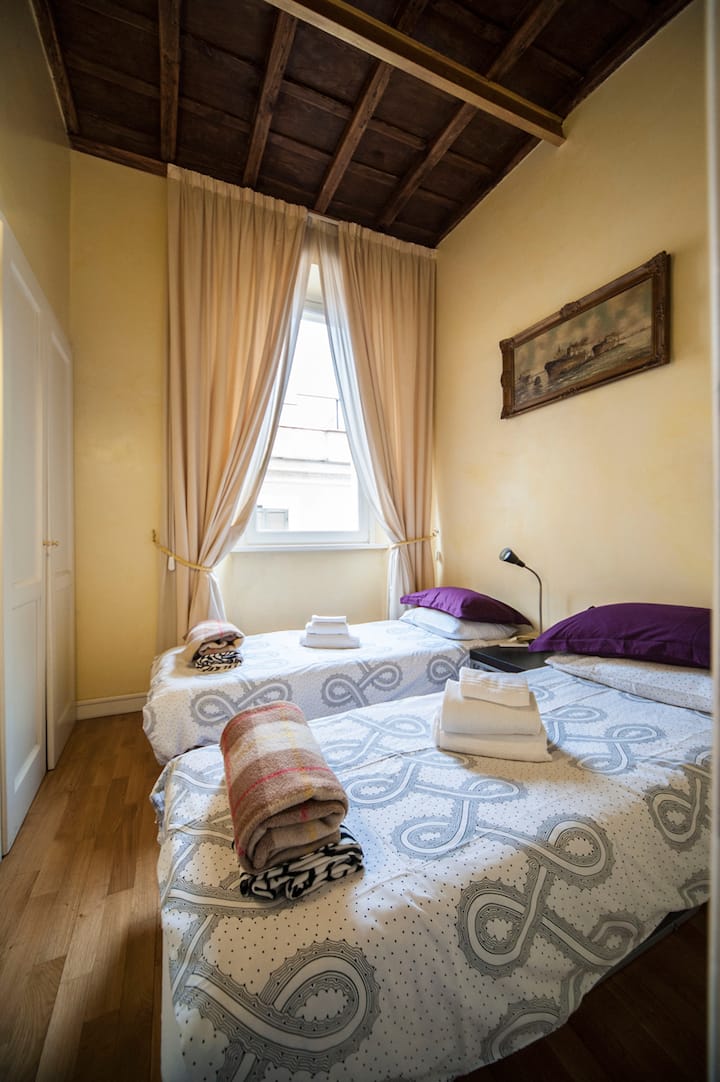 غرفة نوم بسريرين مفردين يطلان على قبة البانثيون