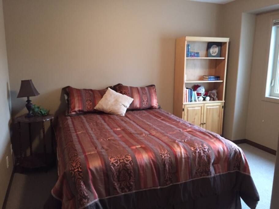 Large room with cozy queen-sized bed. Plenty of floor space for travel crib or desk and chair as needed or requested by quests. Also a very large closet with shelves for folded clothes.