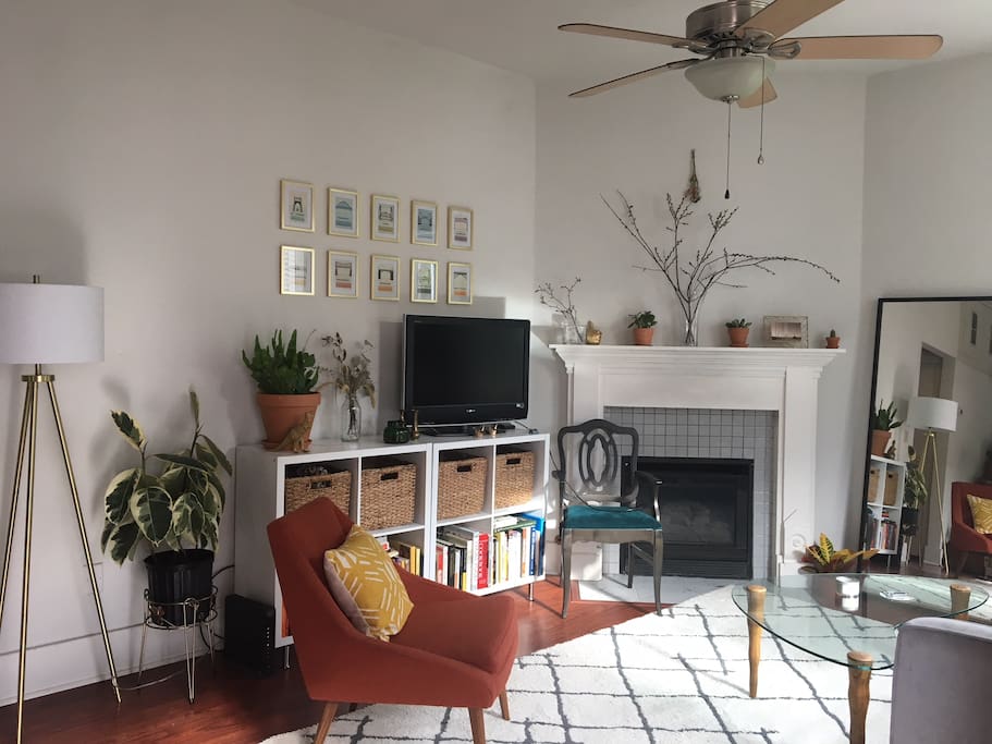 Living room with electric fireplace, one couch and chairs