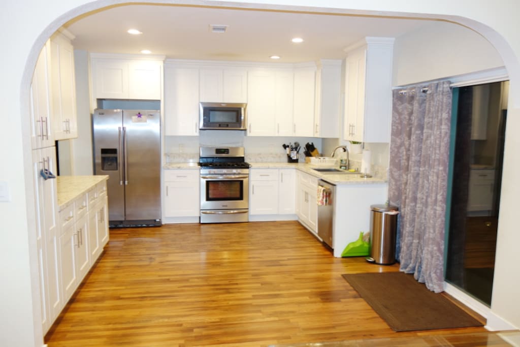 Open concept kitchen with stainless steel appliances, including gas stove and dishwasher.