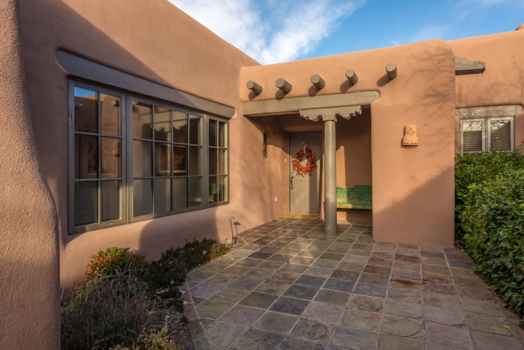 Enclosed patio with authentic vigas and adobe architecture.