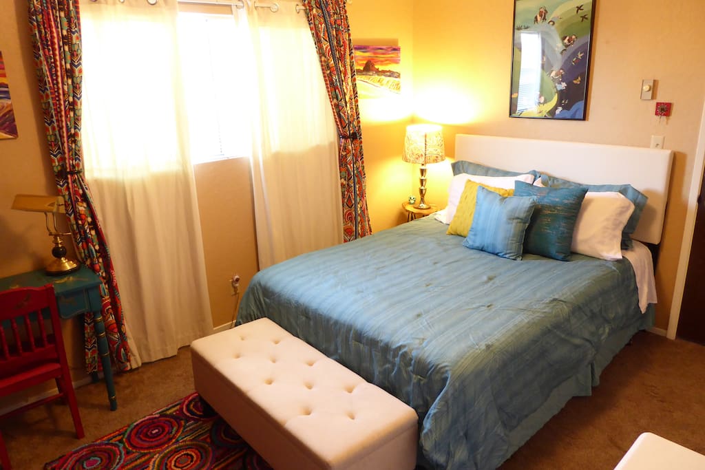 Guestroom with queen bed and blackout curtains (super dark when both sets closed).