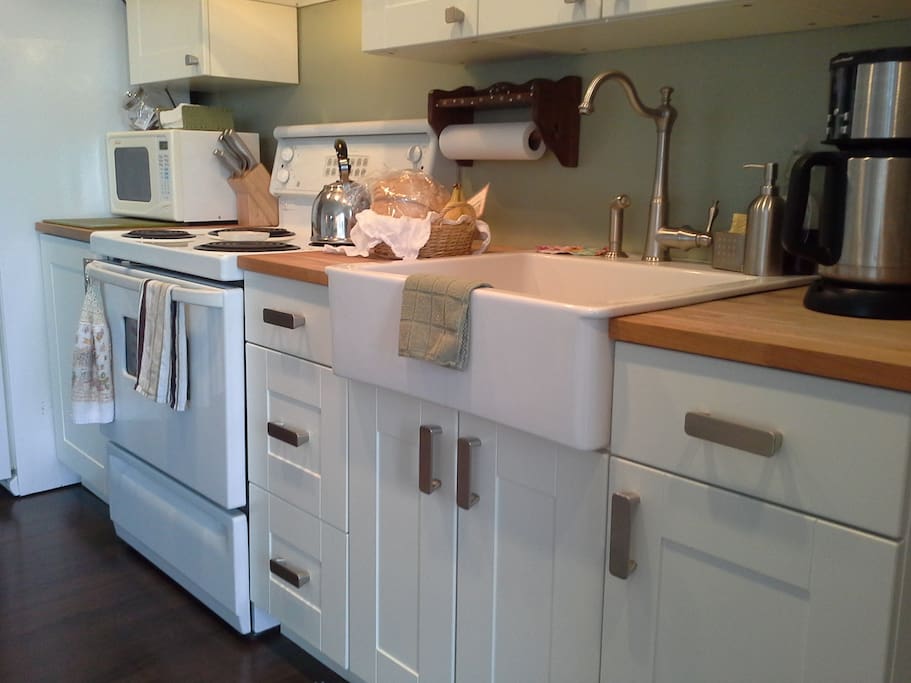 Galley kitchen with fridge, microwave, stove, oven and coffee maker.