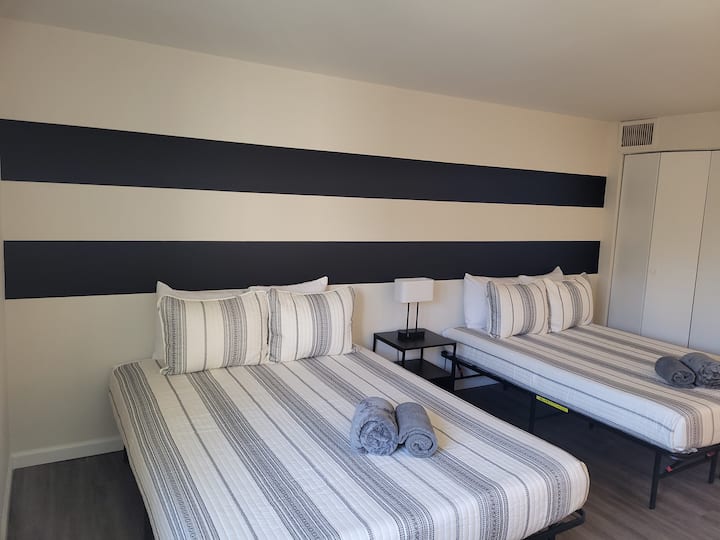 Hip Second Bedroom featuring Two King Sized Beds, Smart TV, Private Bathroom, & Work Desk