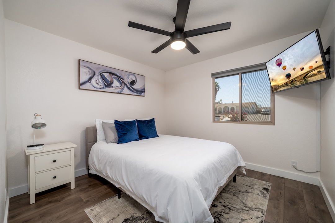 卧室2配有标准双人床、智能电视和镜面衣柜。