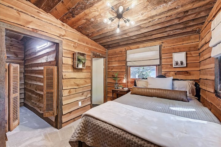 חדר שינה ראשי עם מיטת קווין סייז, עם דלתות סלון וחדר רחצה צמוד