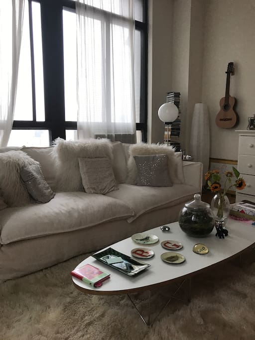 Super comfy sofa surrounding by pillows and a soft carpet