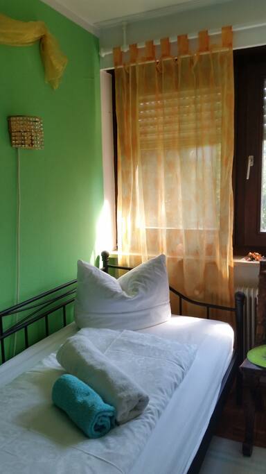 Ein Bett vor dem Fenster.
A bed in front of the window.
