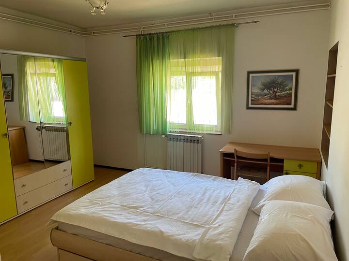 Pogled u ogledalo iz kreveta. U ormarima dodatna posteljina. Radni stol.