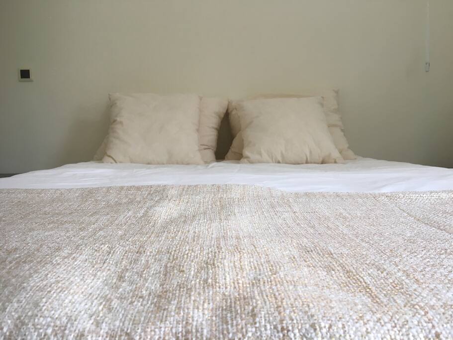 Cama de casal num quarto cheio de luz