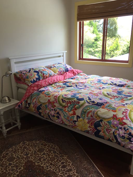 Bright and colourful bedroom with Very comfortable double bed. Wake up listening to birds and looking out at trees and hills