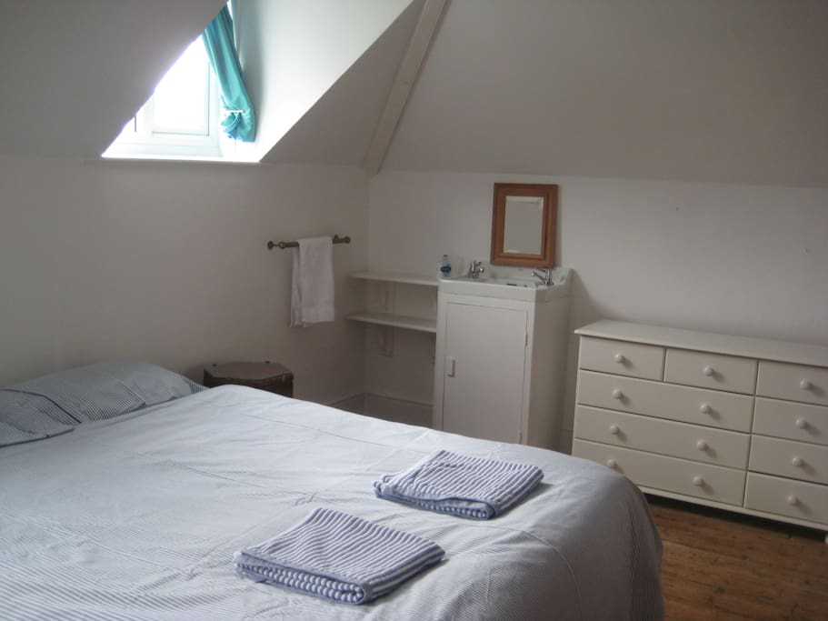 Spacious double bedroom with view of sink.