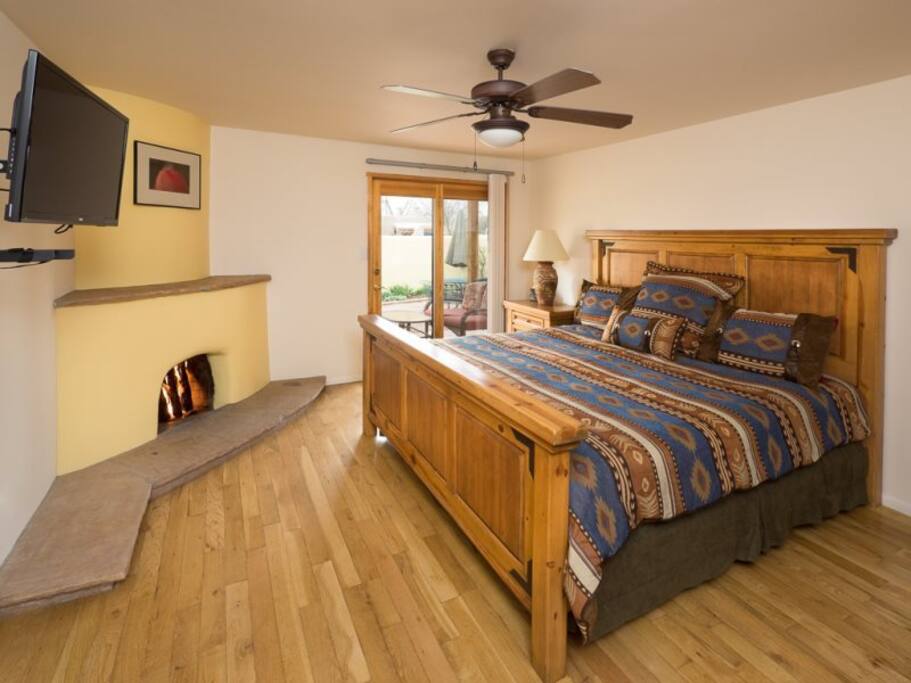 Master bedroom with queen bed, flat-screen tv, and exit to back patio
