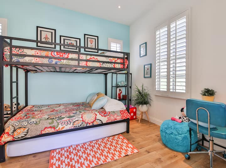 La chambre colorée pour enfants avec un lit superposé complet + un matelas double supplémentaire sur le sol, afin que tous les enfants/adolescents puissent rester ensemble.