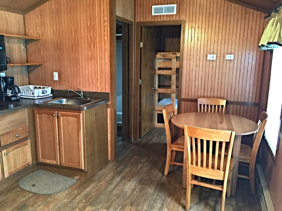 kitchenette with 4 person table , bunk beds and bath in background