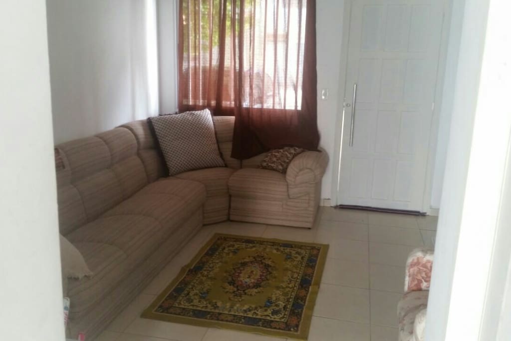 Sala com sofá em L, possui televisão e DVD