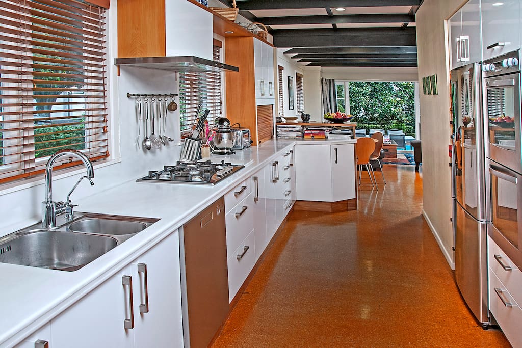 Kitchen flowing to living room and then to deck and pool