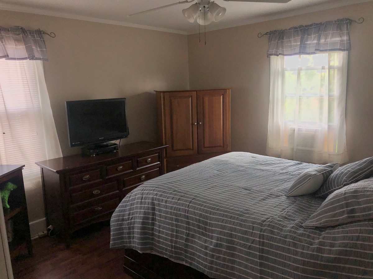 Habitación principal con cama cómoda y espacio en la cómoda. Este dormitorio está ubicado en el mismo nivel que la sala de estar. 