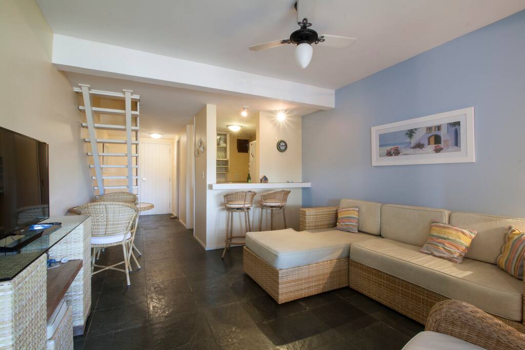 Sala com TV e ventilador de teto.