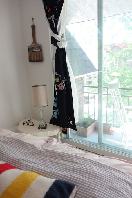 your bed, next to a French window