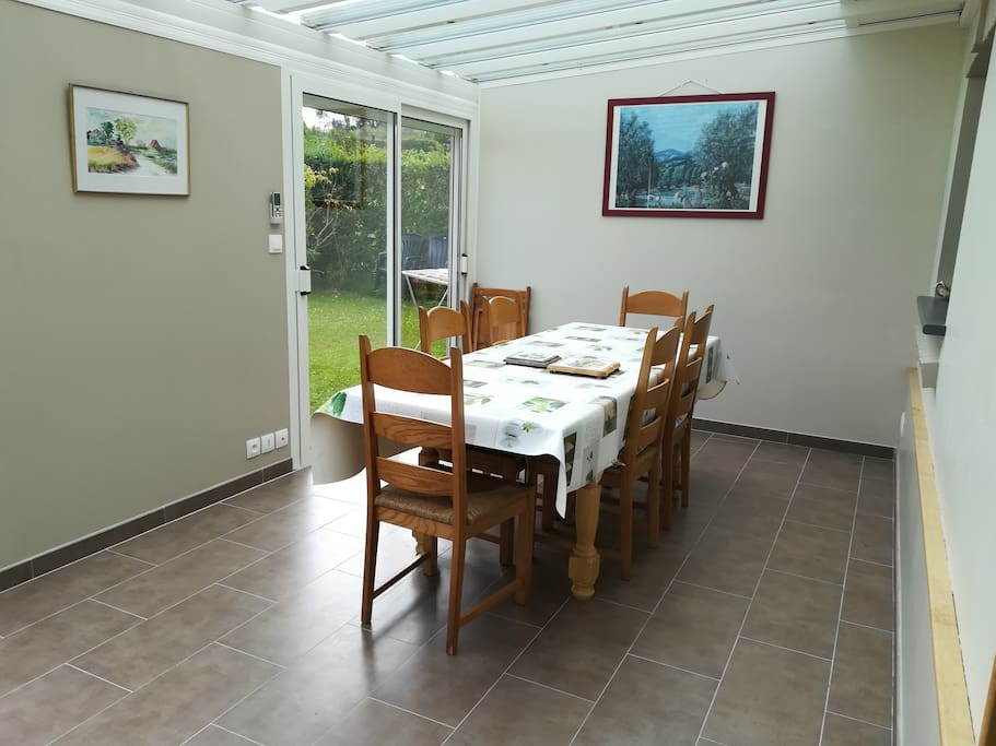 dans la vérandas, lieu agréable pour partager le repas avec table à manger + chaises