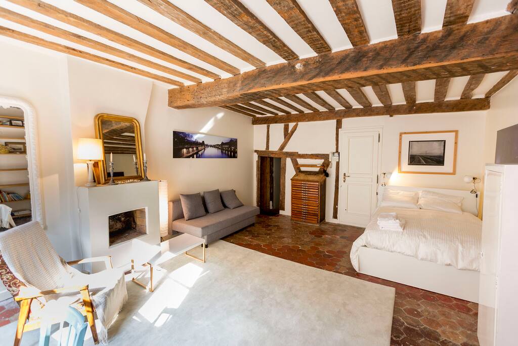 The Main Room (it's about 30 m2) which has a very spacious "feel" to it. Kept as close to it's original 1643 look, with original floor, ceilings, open fire place (basically everything is original except the modern necessities). In this photo the Sofa/bed is used as a sofa. The opening on the left side of the far wall leads to the corridor that brings guests to the toilet, bathroom and kitchen.