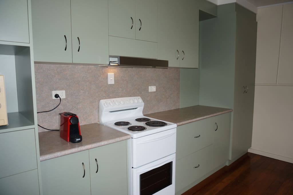 Kitchen equipped with microwave, coffee machine, stove, toaster, kettle