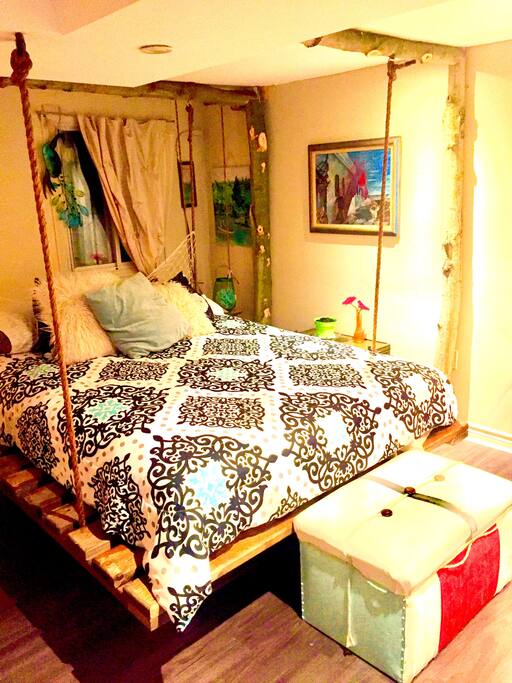 The swing bed, a queen bed supported by a real tree frame